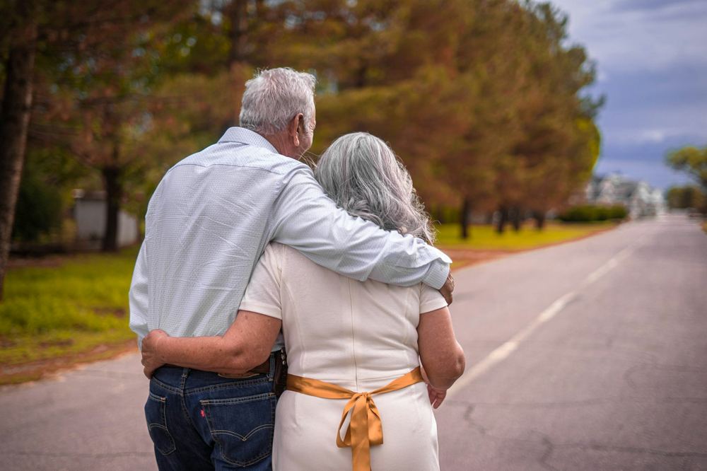 An older couple walking arm in arm